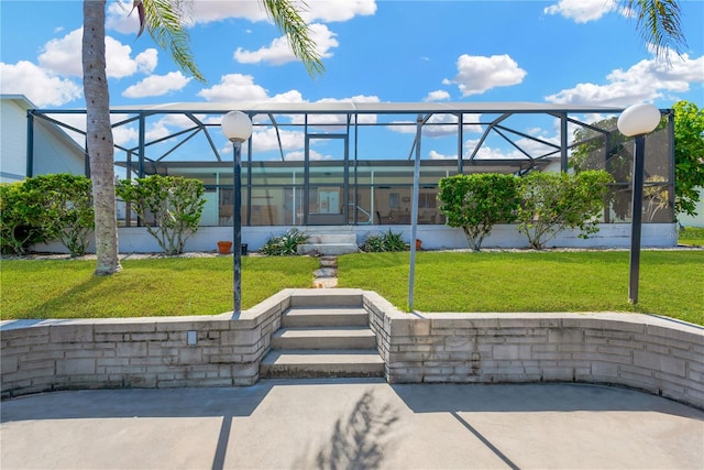 rear view of property with a lanai and a lawn