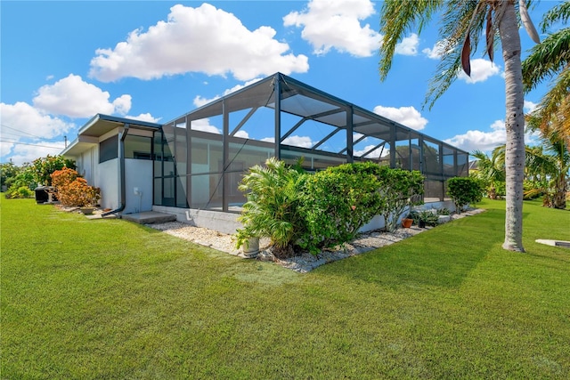 back of house with a lawn and a lanai