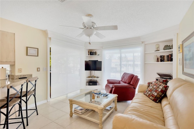 living room with built in shelves, a textured ceiling, light tile patterned floors, and ceiling fan