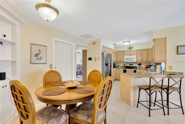 tiled dining room featuring a textured ceiling and sink