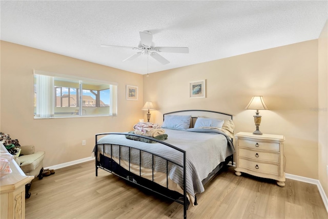 bedroom featuring ceiling fan, a textured ceiling, and light hardwood / wood-style flooring