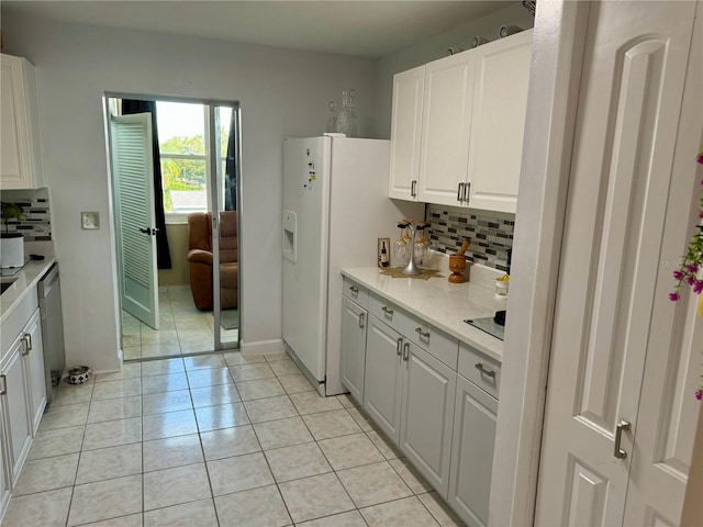 kitchen with decorative backsplash, white cabinets, light tile patterned flooring, and white refrigerator with ice dispenser