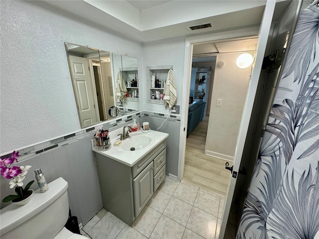 bathroom featuring tile patterned flooring, vanity, and toilet