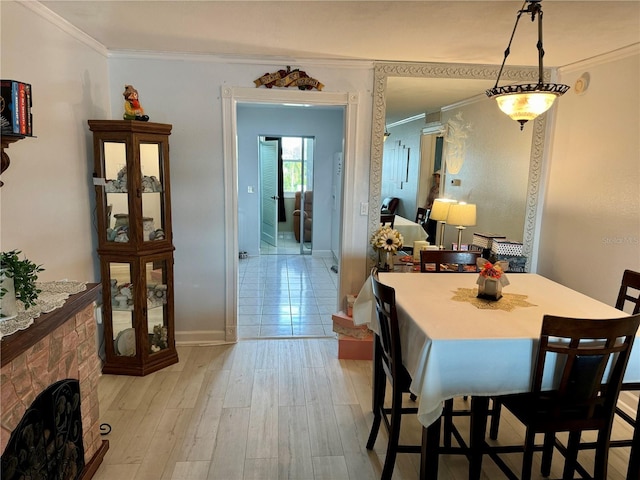 dining space with light hardwood / wood-style flooring and ornamental molding