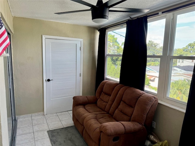 living area with ceiling fan and light tile patterned flooring