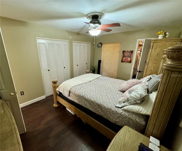 bedroom featuring dark hardwood / wood-style floors, ceiling fan, and multiple closets