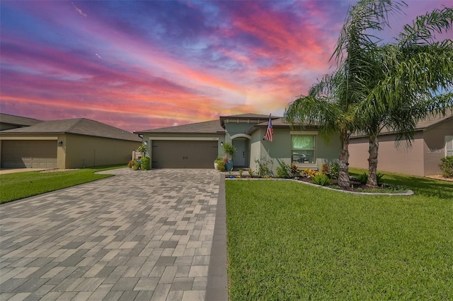 view of front of house with a garage and a lawn