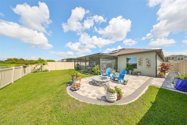 rear view of property with a patio area, a fire pit, a sunroom, a lawn, and solar panels