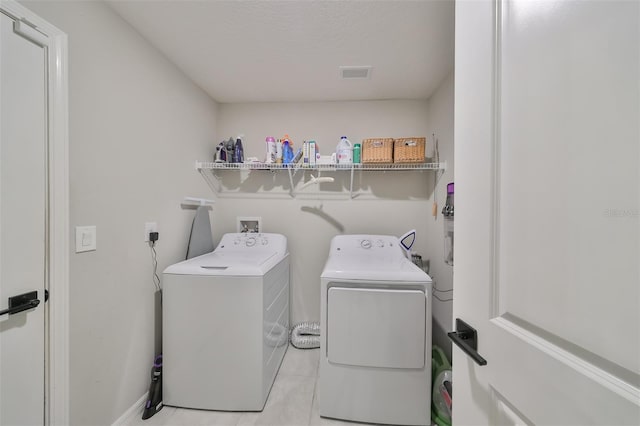 laundry room with light tile patterned floors and washer and dryer