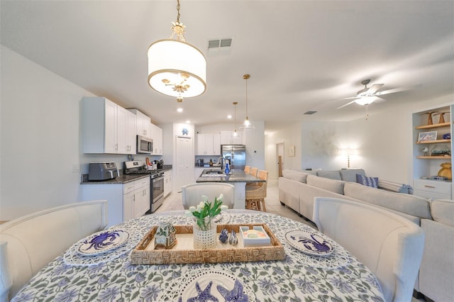 dining space featuring ceiling fan and sink