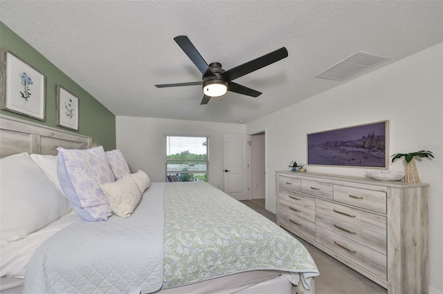 bedroom with ceiling fan and a textured ceiling