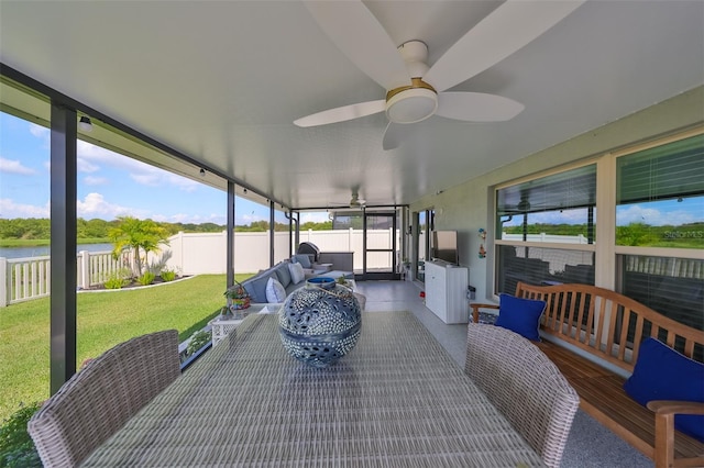 sunroom with a water view and ceiling fan