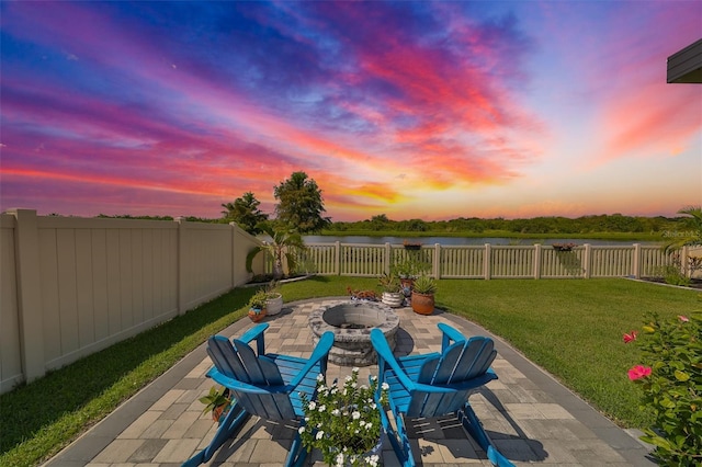 patio terrace at dusk with a lawn and a fire pit