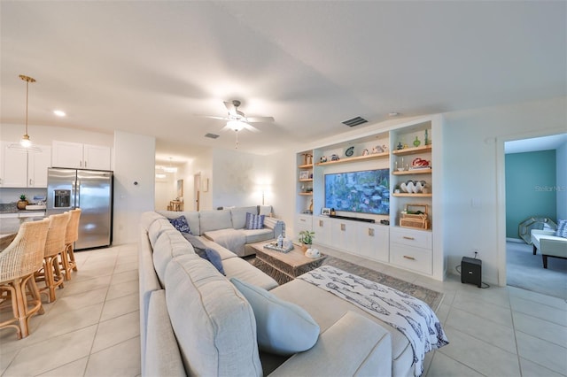 living room featuring vaulted ceiling, ceiling fan, and light tile patterned floors