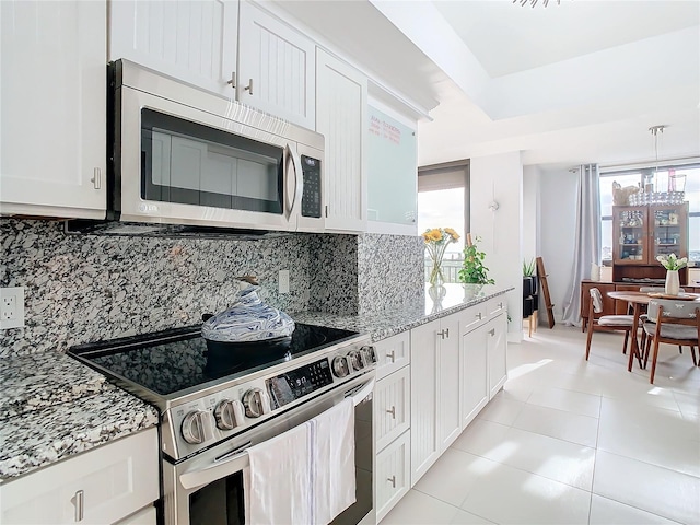 kitchen with white cabinetry, decorative backsplash, and stainless steel appliances