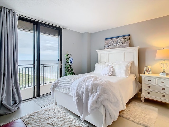 bedroom featuring a water view and access to exterior