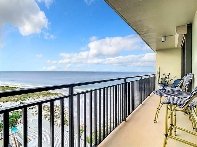 balcony with a water view and a beach view