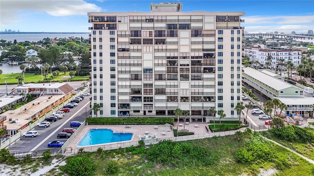 view of building exterior with a water view and a community pool