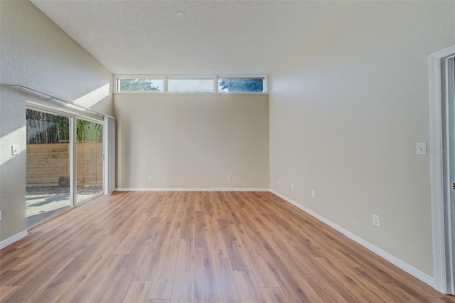 spare room featuring a textured ceiling and light hardwood / wood-style floors