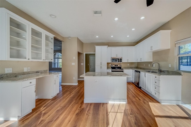 kitchen featuring a center island, sink, light hardwood / wood-style flooring, white cabinetry, and stainless steel appliances