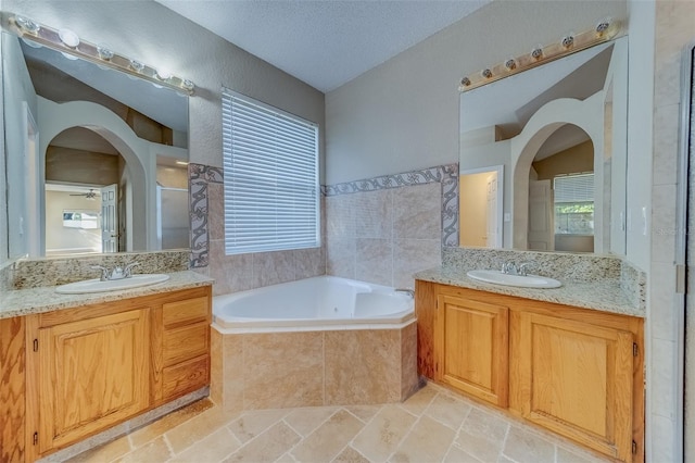 bathroom featuring vanity, shower with separate bathtub, a textured ceiling, and ceiling fan