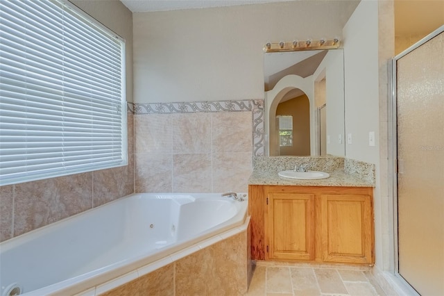 bathroom featuring shower with separate bathtub, vanity, and tile patterned floors