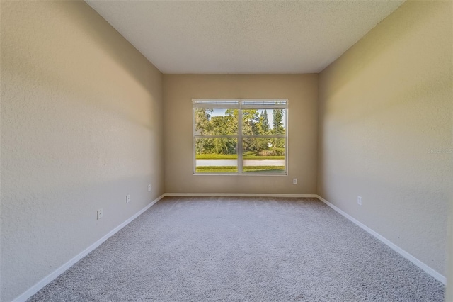 carpeted empty room featuring a textured ceiling