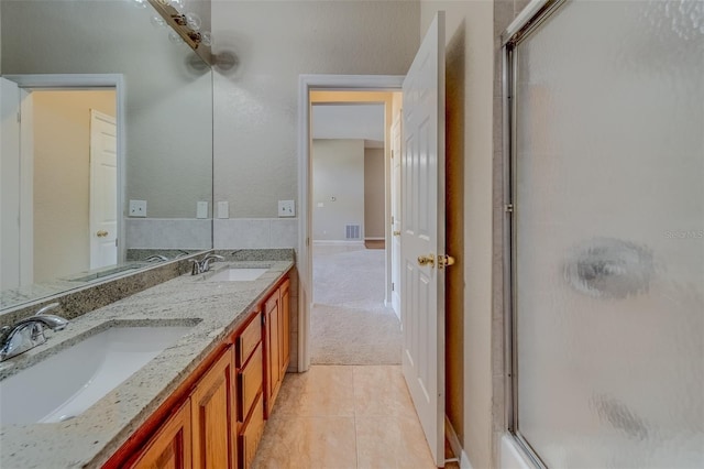 bathroom featuring vanity, tile patterned floors, and a shower with shower door