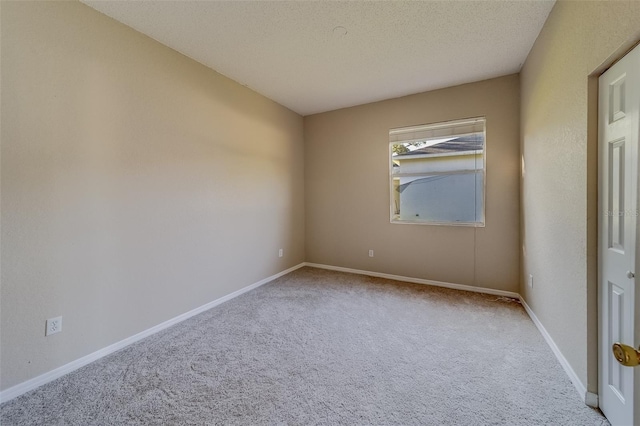 carpeted spare room featuring a textured ceiling