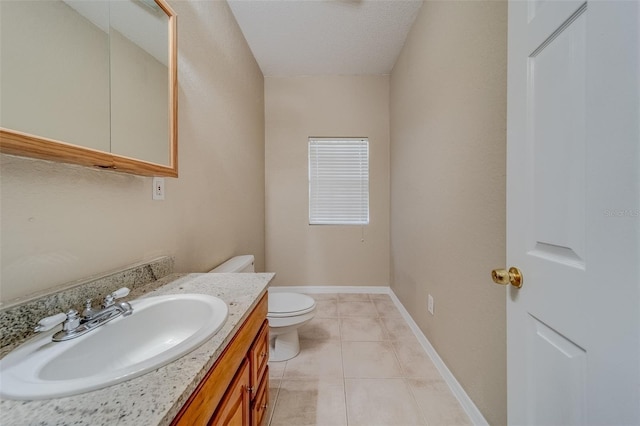 bathroom with toilet, a textured ceiling, vanity, and tile patterned floors