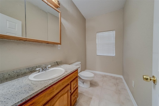 bathroom with tile patterned floors, vanity, a textured ceiling, and toilet