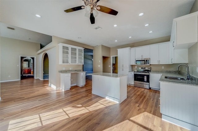 kitchen featuring white cabinets, a kitchen island, sink, and stainless steel appliances