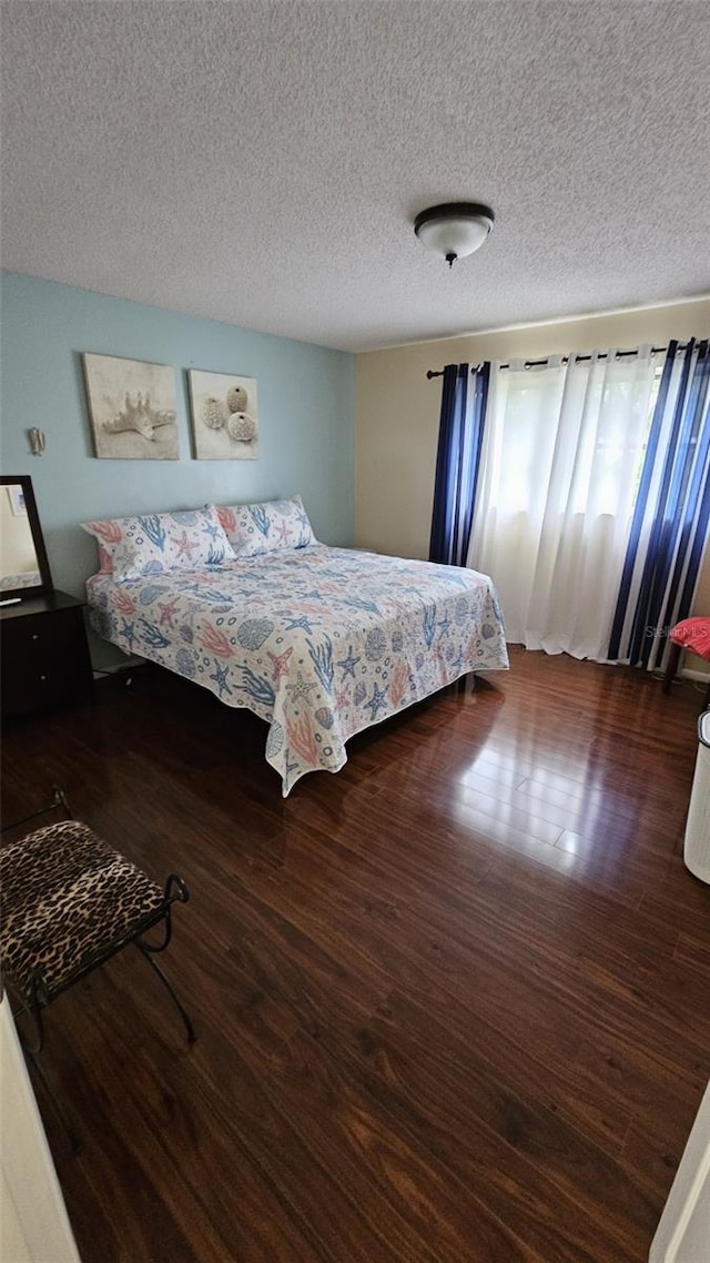 bedroom featuring a textured ceiling and dark hardwood / wood-style floors