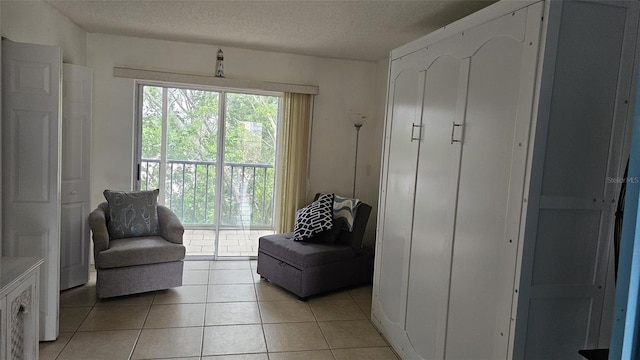 sitting room featuring a textured ceiling and light tile patterned flooring