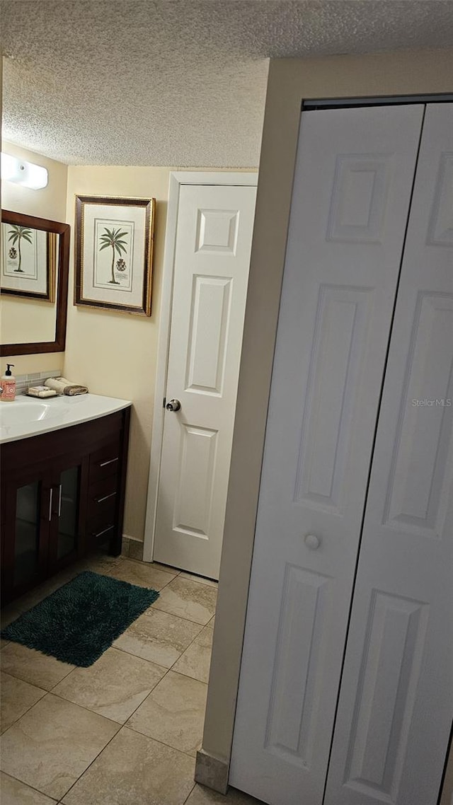 bathroom featuring tile patterned flooring, a textured ceiling, and vanity