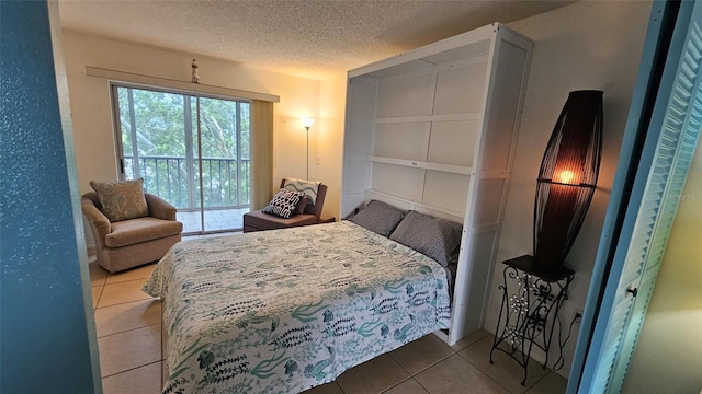 tiled bedroom with a textured ceiling and access to exterior