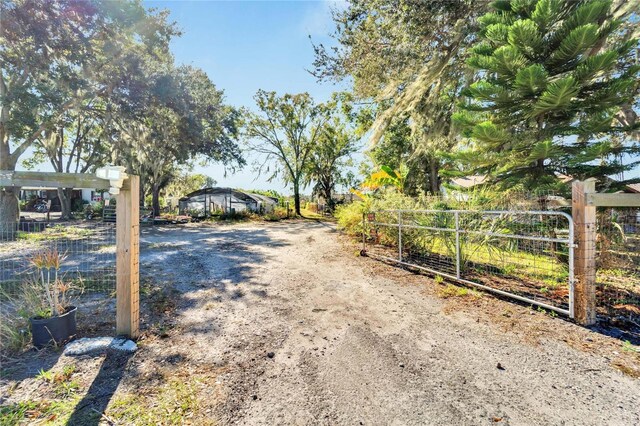 view of street featuring a gated entry and dirt driveway