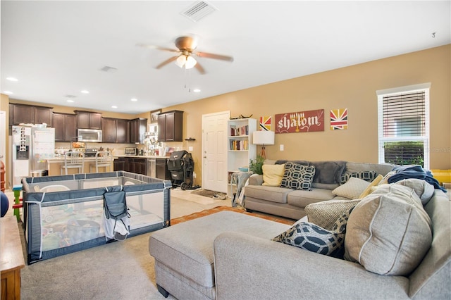 living room featuring ceiling fan and light colored carpet