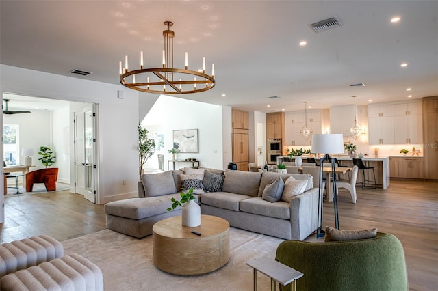 living room featuring an inviting chandelier and light wood-type flooring