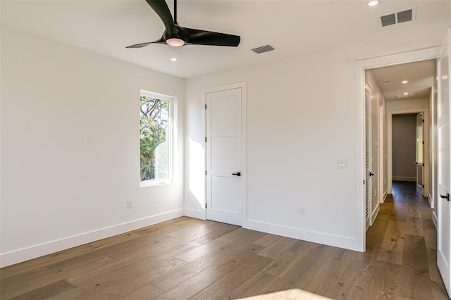 empty room featuring ceiling fan and dark hardwood / wood-style flooring