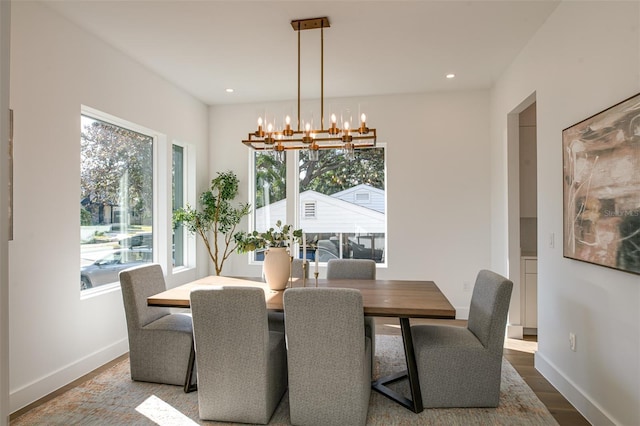 dining space featuring hardwood / wood-style floors, a wealth of natural light, and a notable chandelier