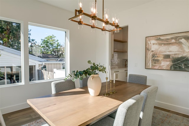 dining room with dark wood-type flooring and a chandelier