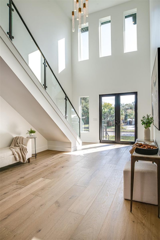 living room featuring a high ceiling, plenty of natural light, and french doors