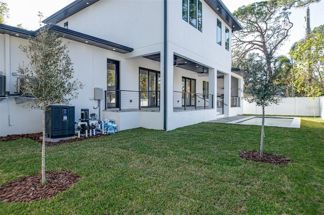 rear view of property featuring a patio, ceiling fan, and a lawn