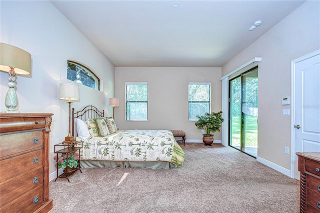 bedroom with multiple windows, light carpet, and access to exterior