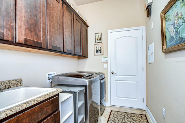 washroom with separate washer and dryer, light tile patterned floors, and cabinets