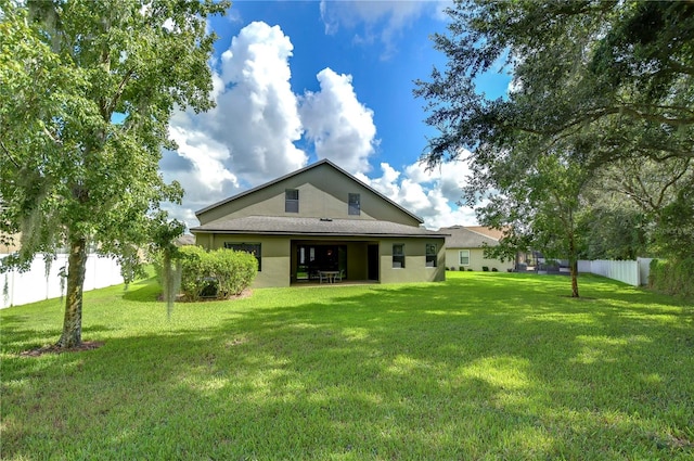 rear view of property with a yard