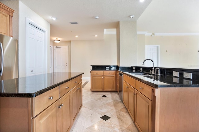 kitchen with a kitchen island, stainless steel appliances, dark stone countertops, sink, and crown molding