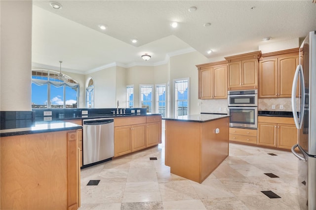 kitchen with a wealth of natural light, stainless steel appliances, a kitchen island, and sink