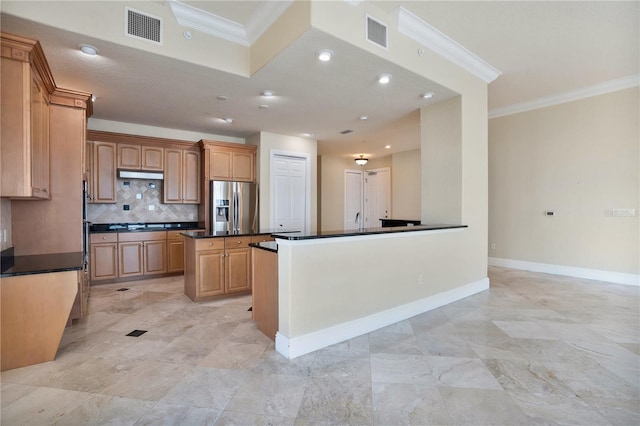 kitchen with stainless steel fridge, backsplash, a center island, crown molding, and sink